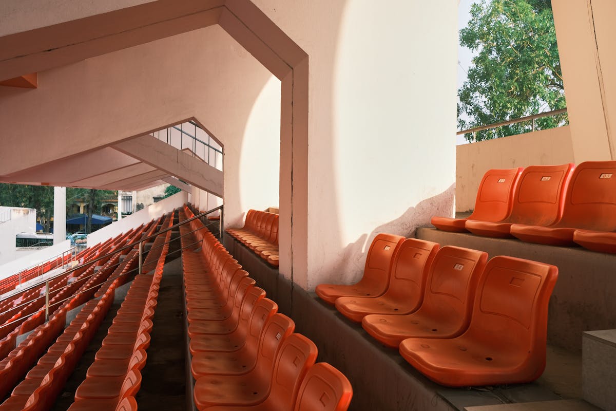 Empty orange stadium seats in Hải Phòng, Vietnam, during the day.